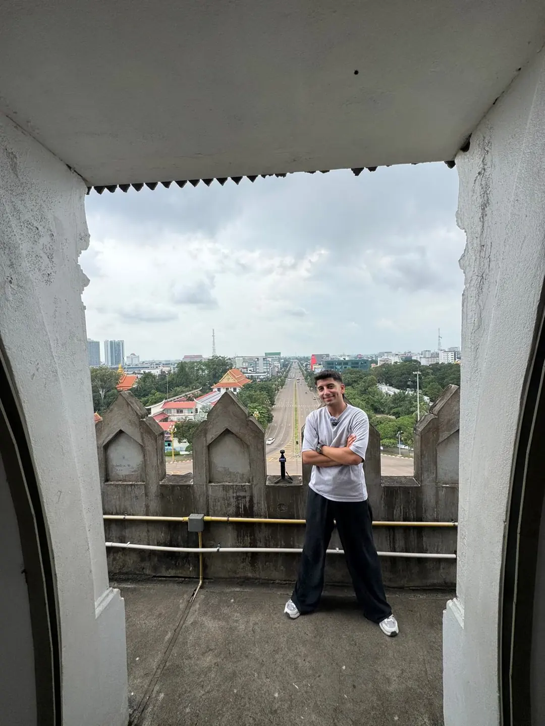 Yiğit, uzun bir caddeye bakan beyaz taş çerçevenin içinde